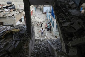 Des Palestiniens inspectent les décombres de l'école Jaouni à Nousseirat dans le centre de Gaza, abritant des déplacés et gérée par l'ONU, où l'armée israélienne a dit avoir visé des 