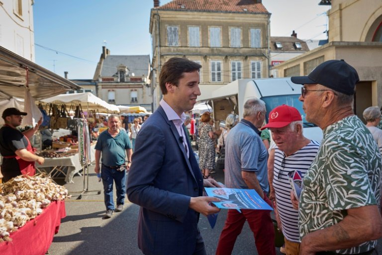 Pierre Gentillet, ex-chroniqueur sur CNews et candidat RN aux législatives dans le Cher, parle avec une habitante sur le marché de Sancoins, le 26 juin 2024