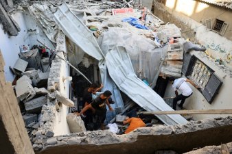Des Palestiniens inspectent les décombres de l'école Jaouni à Nousseirat dans le centre de Gaza, abritant des déplacés et gérée par l'ONU, où l'armée israélienne a dit avoir visé des 