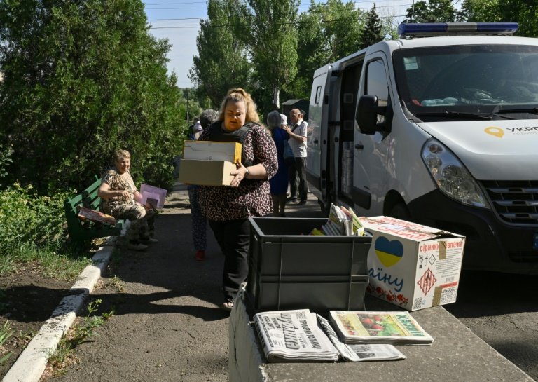 La postière Ganna Fessenko, en gilet pare-balles, s'apprête à distribuer des lettres, colis, pensions et autres prestations sociales dans un village près de la ligne de front, dans la région de Donetsk, le 14 juin 2024 en Ukraine